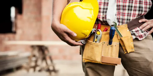 Ouvrier en tenue de chantier avec casque jaune